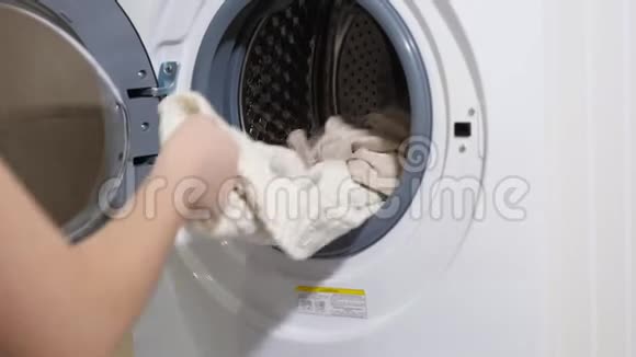 穿着t恤的长发女孩洗着现代洗衣机洗干净的衣服视频的预览图
