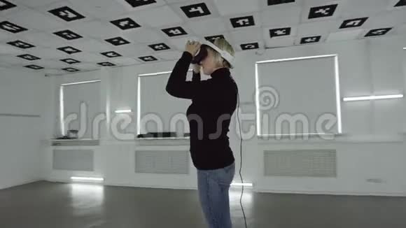 一位年轻的女士戴上了playstation虚拟现实耳机把手臂上下移动用一个耳机取下耳机视频的预览图