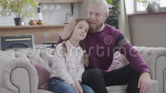 幸福的白种人父亲抚摸女儿的头看着相机微笑着的肖像年轻人和少女视频的预览图