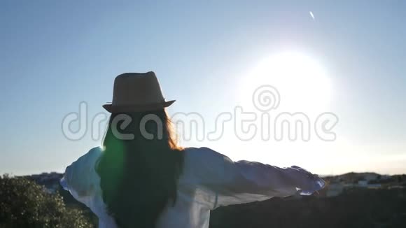 女人站在上面看着城市在黎明时举起双手对着太阳视频的预览图