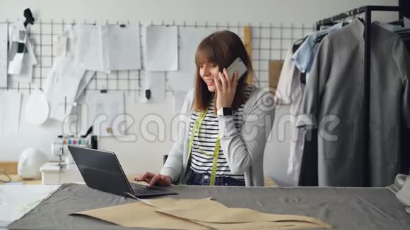 小企业主正在为裁缝店订购布料用手机和笔记本电脑工作女人在说话视频的预览图