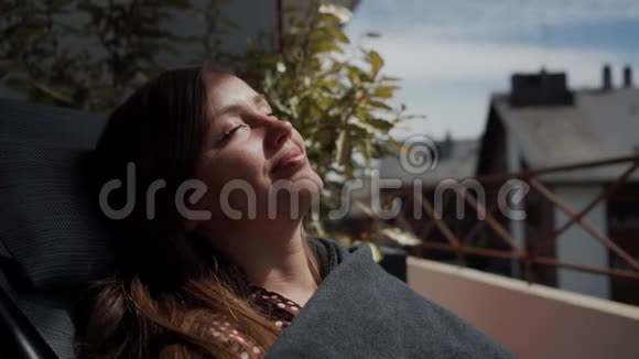 一幅美丽的女孩闭着眼睛享受日光浴的肖像关门视频的预览图