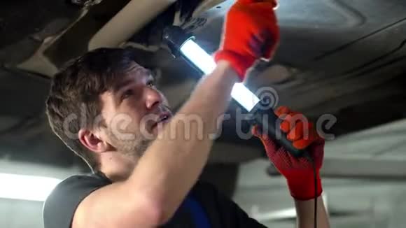 带手电筒的机械师修理一辆汽车关闭视频的预览图