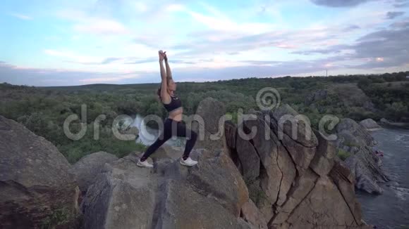 运动的女人在山崖上练习瑜伽和体操有美丽的景观背景健康视频的预览图