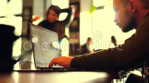 一个自由职业者坐在咖啡馆工作笔记本电脑视频的预览图