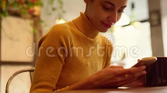 手机年轻美丽的女人短信使用应用程序智能手机在咖啡视频的预览图