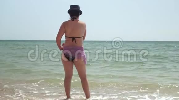 一个晒黑了的女人站在海边视频的预览图