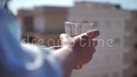 在酒店的阳台上女人喝着玻璃杯里的东西特写旅行度假视频的预览图