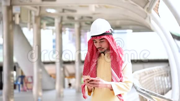 伊斯兰男子使用智能手机应用程序组织日程安排重点是手握智能手机穆斯林现代阿联酋城市阿拉伯男子视频的预览图