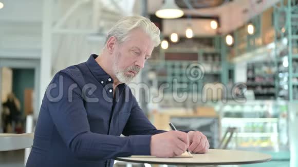 体贴的老人在咖啡厅做文书工作视频的预览图