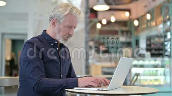 不是老人在咖啡厅用手提电脑做的手指手势视频的预览图