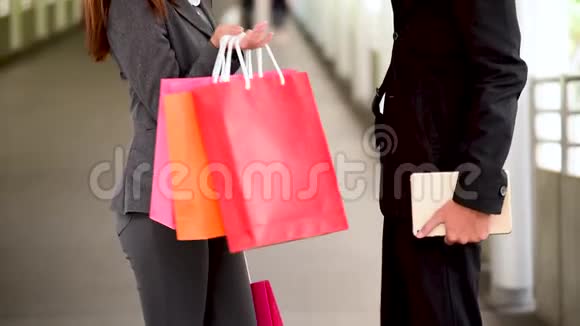 网上购物网站上女人拿着购物袋在零售购物中心购买产品情侣一起买东西视频的预览图