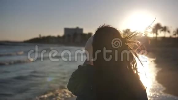 太阳眼镜的女人在日落时戴着帽子在海边慢动作视频的预览图