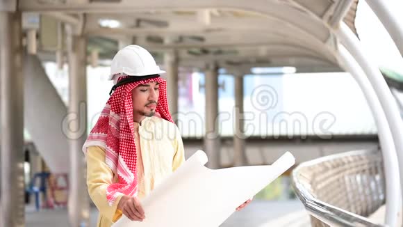 阿拉伯土木工程师建设项目手持蓝图指向建筑工地现代穆斯林阿联酋城市多元文化差异视频的预览图