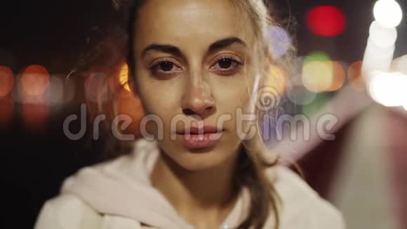 特写美丽悲伤的年轻女子走在户外的夜晚城市慢镜头视频的预览图