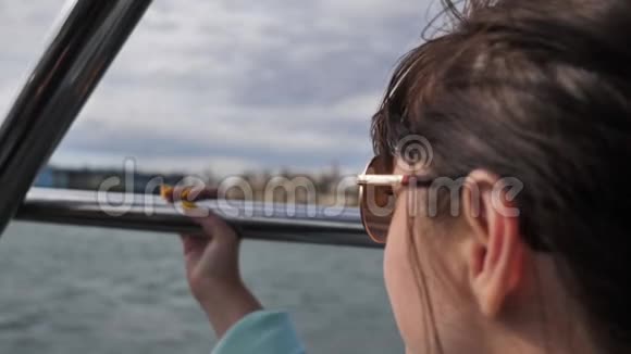 戴墨镜的快乐女人漂浮在船上环顾四周旅行理念慢动作视频的预览图