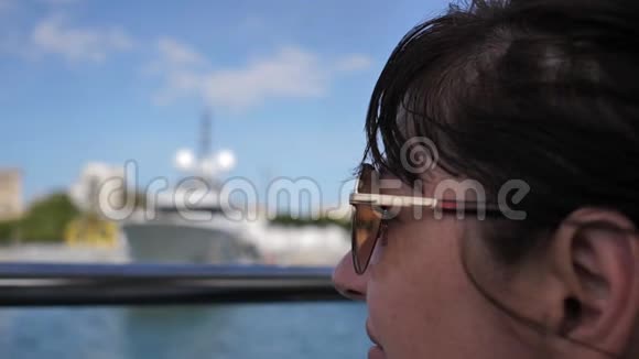 戴墨镜的快乐女人漂浮在船上环顾四周旅行理念慢动作视频的预览图