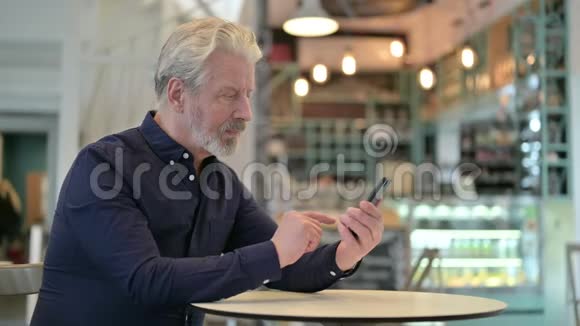 咖啡厅聚焦老人使用智能手机视频的预览图