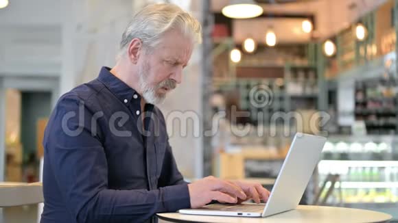 有颈部疼痛的老人使用笔记本电脑视频的预览图
