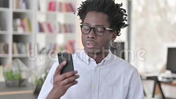 非洲年轻人在智能手机上说话的画像视频的预览图