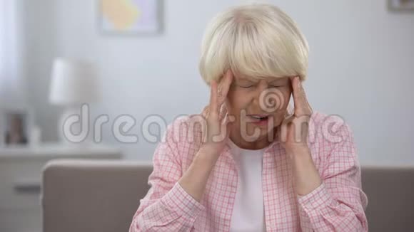 老年妇女按摩疼痛的太阳穴寻找止痛药健康视频的预览图