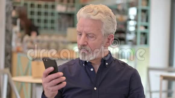 老人在智能手机上说话的画像视频的预览图