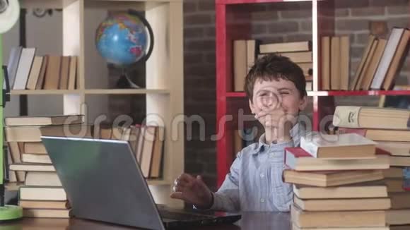 快乐的学生在书桌上打字在笔记本电脑上快乐地笑视频的预览图