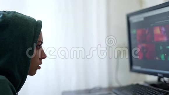 侧视女性程序员自由职业者黑客帽衫使用计算机视频的预览图