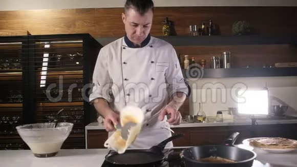 快餐穿围裙的成人厨师把煎饼放在热锅上视频的预览图