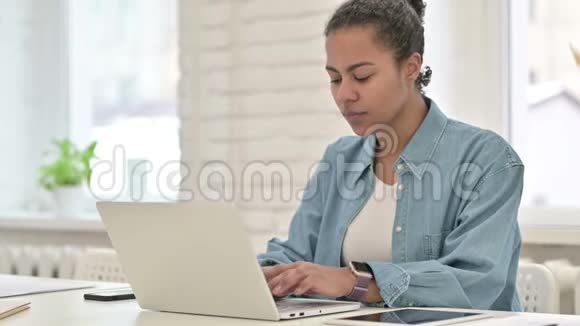 年轻的非洲妇女在笔记本电脑上庆祝成功视频的预览图