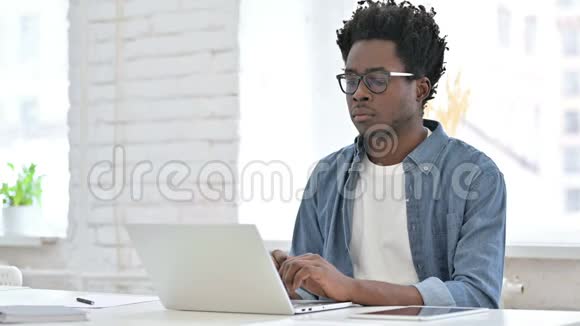 年轻的非洲男人用笔记本电脑工作视频的预览图