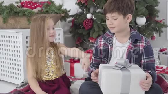 漂亮的白人女士把手给黑发男孩微笑的男孩亲吻女孩手臂可爱的小情侣过圣诞节视频的预览图