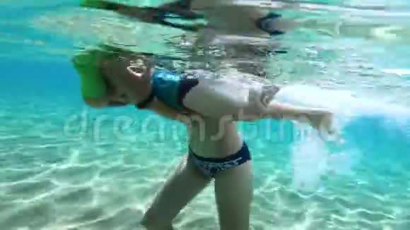一位母亲抱着她的小女儿在水下学习游泳视频的预览图