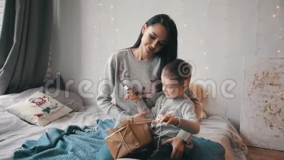 妈妈和儿子在床上打开一个礼品盒视频的预览图