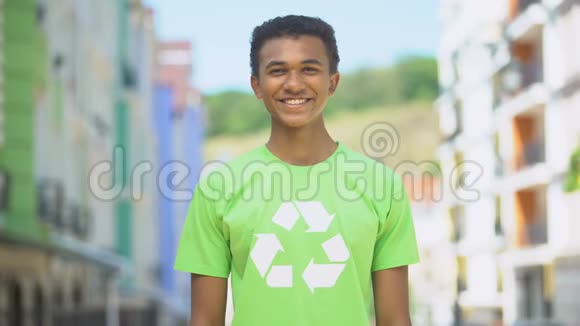 快乐的年轻环保志愿者在回收标志上微笑拯救自然视频的预览图