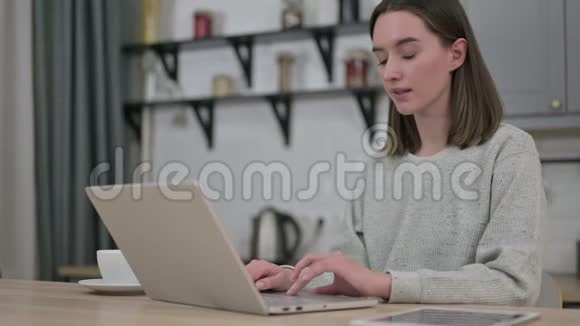 令人惊讶的年轻女性在家的笔记本电脑上感到震惊视频的预览图