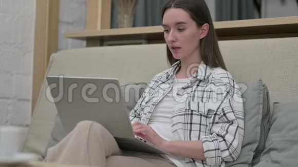 年轻女子在沙发笔记本电脑上面对失败视频的预览图