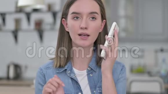 美丽的年轻创意女性在智能手机上说话的画像视频的预览图