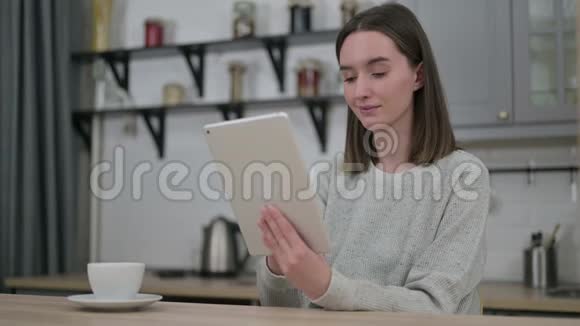 在客厅使用平板电脑的年轻女性视频的预览图