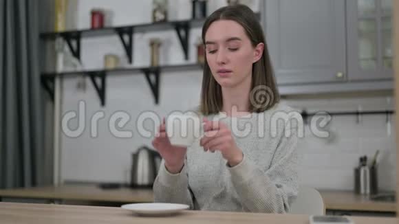 有魅力的年轻女性在客厅喝咖啡视频的预览图