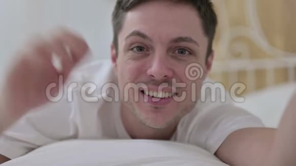 年轻人在床上视频聊天的网络摄像头视图视频的预览图