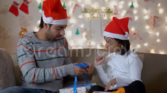 印度的父亲和女儿包装圣诞礼物聊天视频的预览图