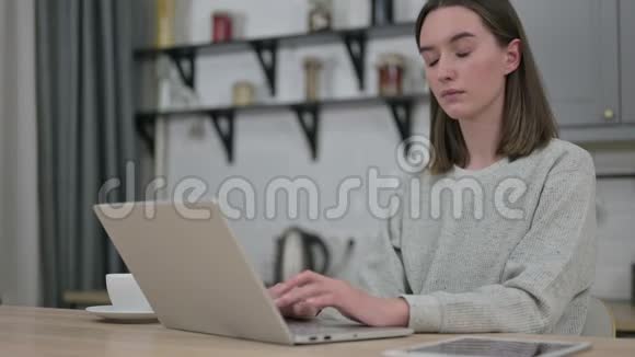 美丽的年轻女子在做手提电脑和颈部疼痛视频的预览图