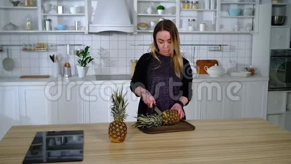 女孩在厨房把菠萝切成小圆圈视频的预览图