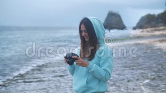 女孩拍摄照片视频dslr无镜相机海洋背景4k视频的预览图