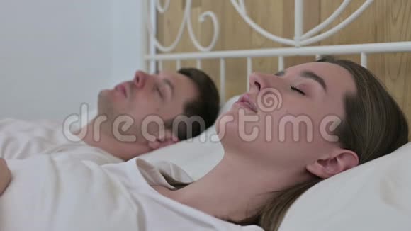 安睡在床上的轻松年轻夫妇视频的预览图