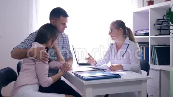 女性健康沮丧的夫妻不育问题坐在她们的女医生面前在医疗办公室视频的预览图