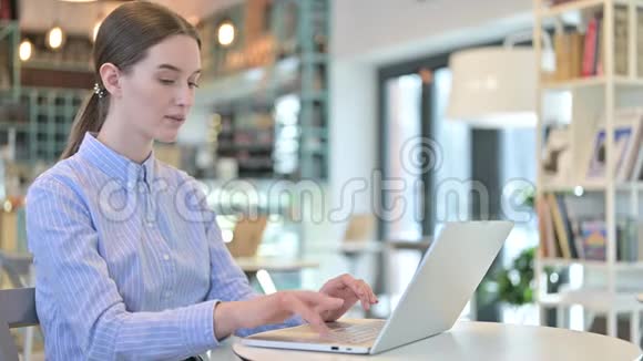 年轻女商人在咖啡馆里庆祝笔记本电脑视频的预览图