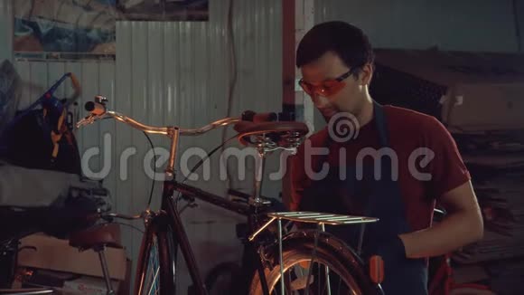主题小企业自行车修复一个年轻的白种人黑发男子戴着安全护目镜手套和围裙用手视频的预览图