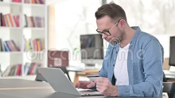 青少年在手提电脑眼镜网上购物成功视频的预览图